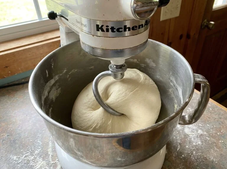 Overnight cinnamon rolls with heavy cream being pulled apart showing fluffy interior and cream cheese frosting